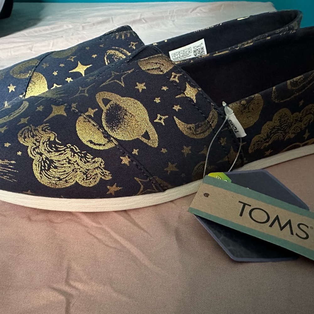 NWT TOMS Black and Gold Cosmic Slip-On Shoes